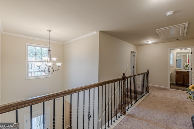 corridor featuring attic access, ornamental molding, carpet flooring, an upstairs landing, and baseboards