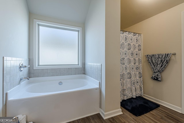 full bath with curtained shower, a garden tub, baseboards, and wood finished floors