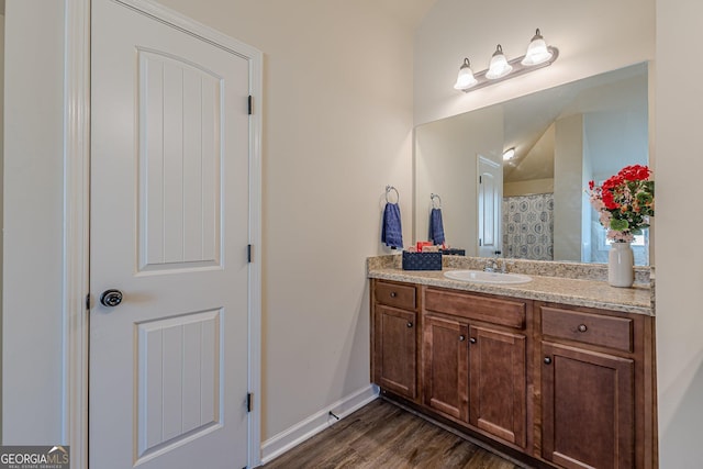 bathroom featuring vanity, baseboards, and wood finished floors