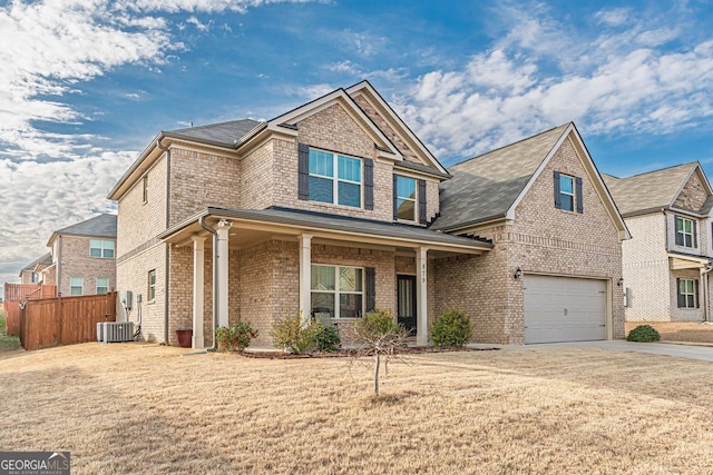 view of front of property featuring concrete driveway, an attached garage, fence, a front lawn, and brick siding