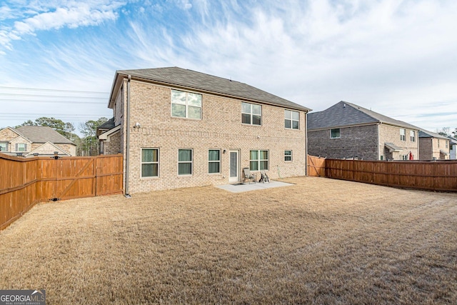 back of property with brick siding, a yard, a fenced backyard, and a patio