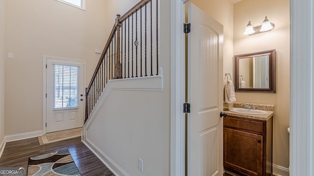 entrance foyer featuring dark wood-style floors, baseboards, and stairway