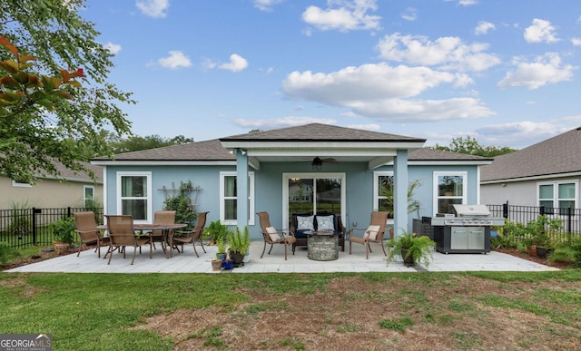 back of property featuring a yard, stucco siding, a ceiling fan, a patio area, and fence