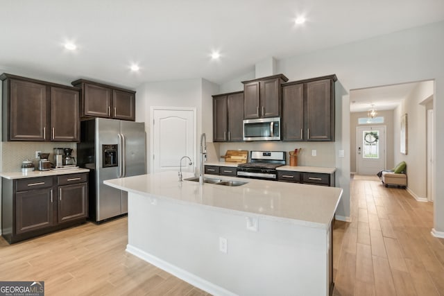 kitchen featuring dark brown cabinetry, appliances with stainless steel finishes, light countertops, and a sink