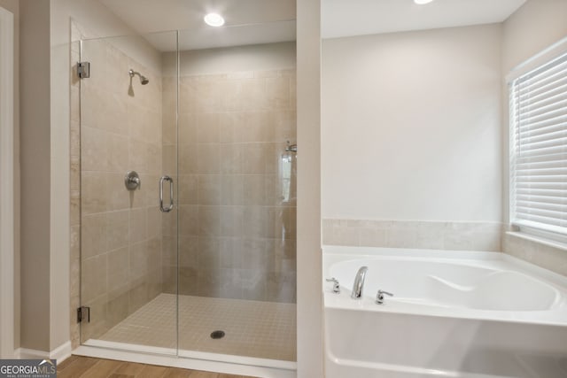 full bathroom featuring a shower stall and a bath