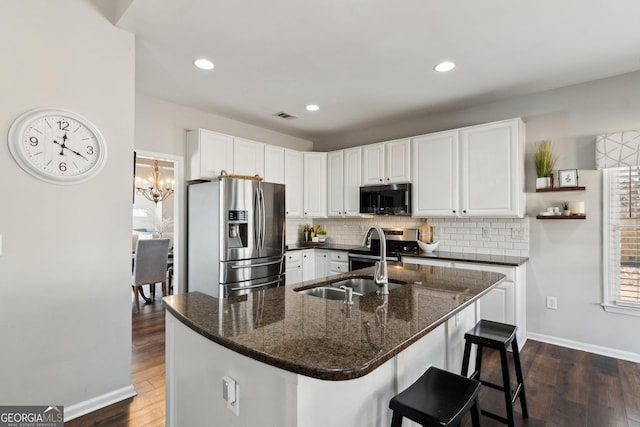 kitchen featuring decorative backsplash, dark wood-style flooring, stainless steel appliances, white cabinetry, and a sink