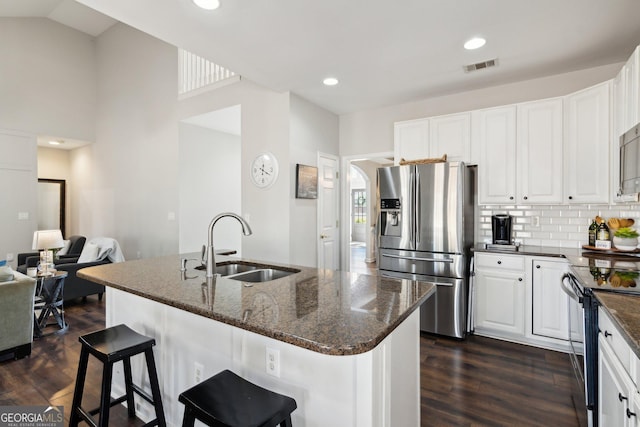 kitchen featuring black / electric stove, a sink, visible vents, stainless steel fridge, and dark wood finished floors