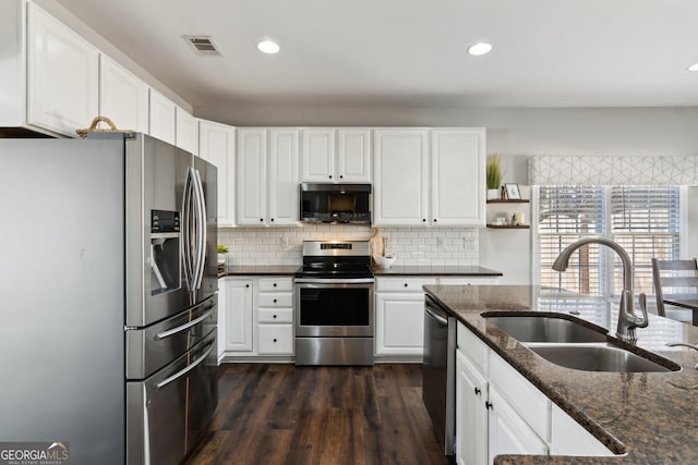 kitchen featuring visible vents, backsplash, appliances with stainless steel finishes, white cabinetry, and a sink