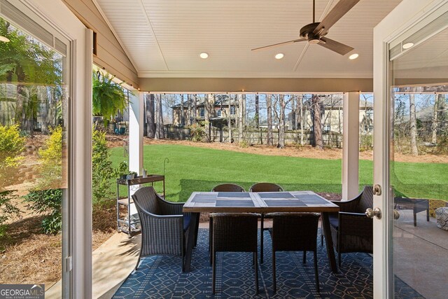 view of patio featuring outdoor dining area, fence, and a ceiling fan