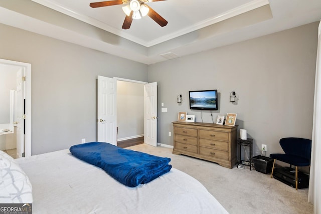 carpeted bedroom with a ceiling fan, connected bathroom, a raised ceiling, and crown molding