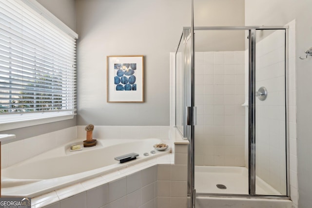 bathroom with a stall shower and a bath