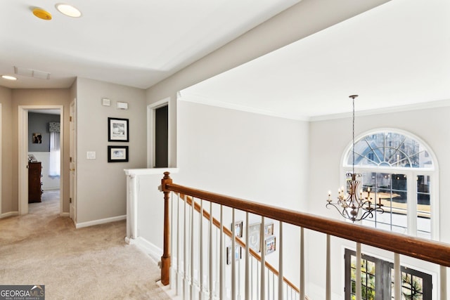 hall with visible vents, light carpet, an upstairs landing, a chandelier, and baseboards