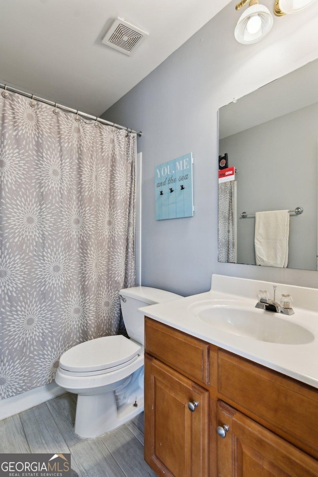 full bath featuring toilet, visible vents, and vanity