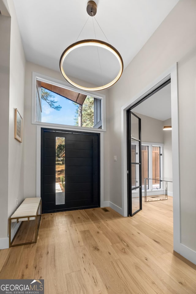 foyer with light wood-type flooring and baseboards