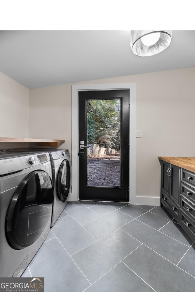 washroom featuring washer and dryer, laundry area, tile patterned flooring, and baseboards