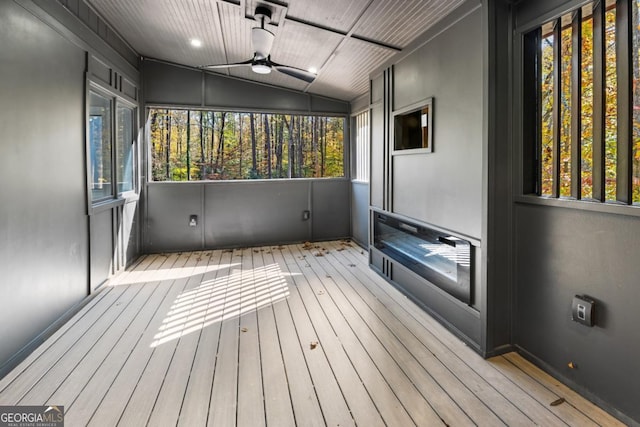 interior space with a ceiling fan, wood-type flooring, and vaulted ceiling