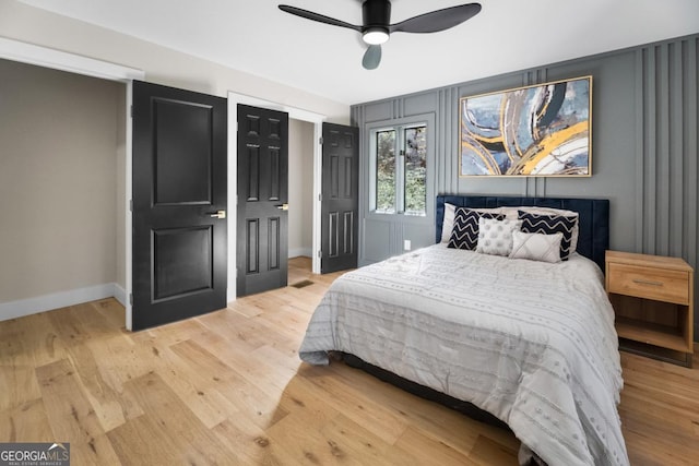 bedroom with a ceiling fan, light wood-type flooring, and baseboards