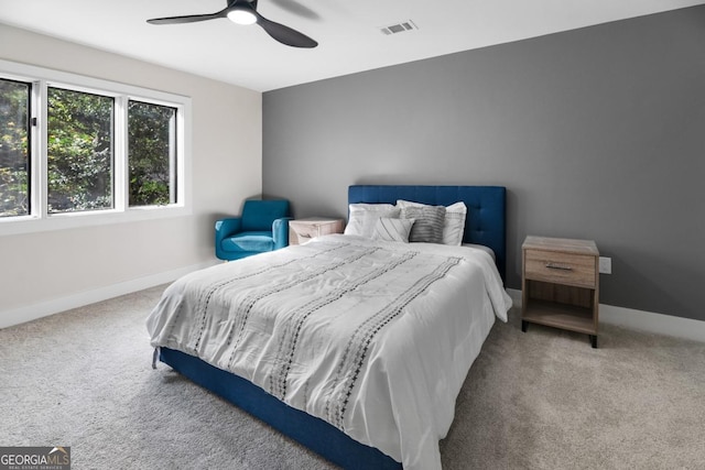 carpeted bedroom featuring a ceiling fan, visible vents, and baseboards