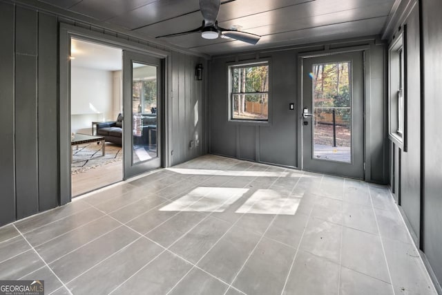 doorway to outside with ceiling fan and light tile patterned floors