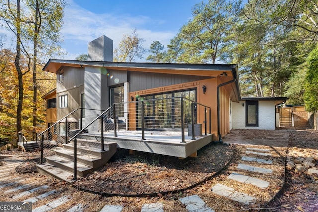 back of house featuring a deck and a chimney