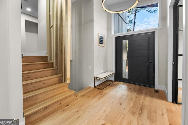 foyer with stairway and hardwood / wood-style flooring