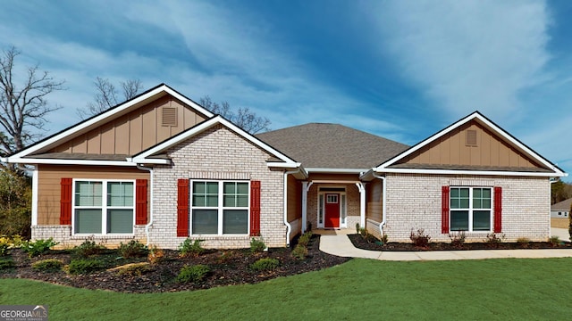 craftsman-style house featuring board and batten siding, brick siding, and a front lawn