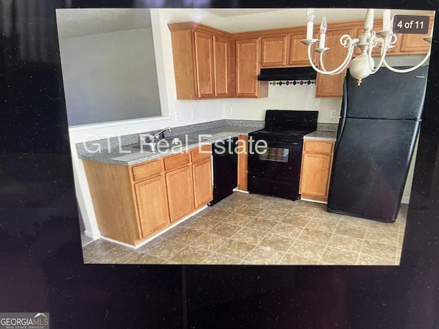 kitchen with black appliances and under cabinet range hood