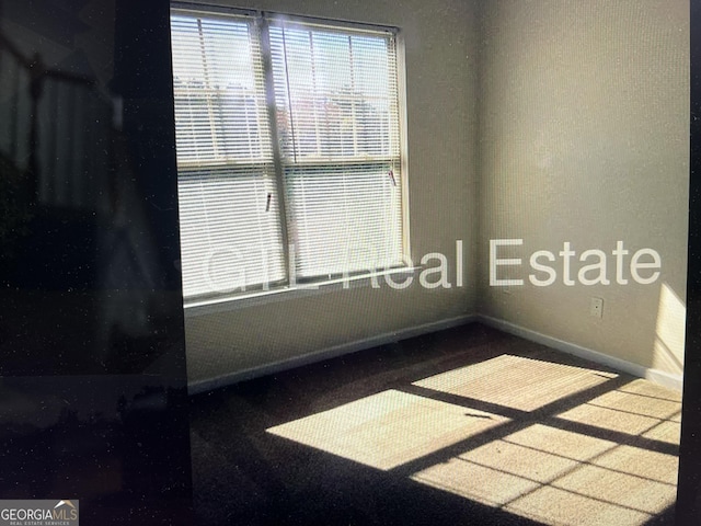 carpeted spare room with baseboards