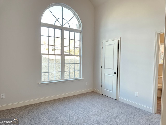 carpeted spare room with baseboards and a wealth of natural light