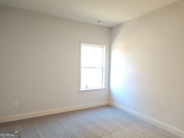 empty room featuring carpet floors and baseboards