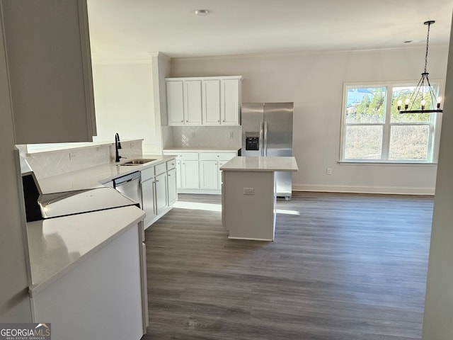 kitchen featuring tasteful backsplash, stainless steel appliances, crown molding, light countertops, and a sink