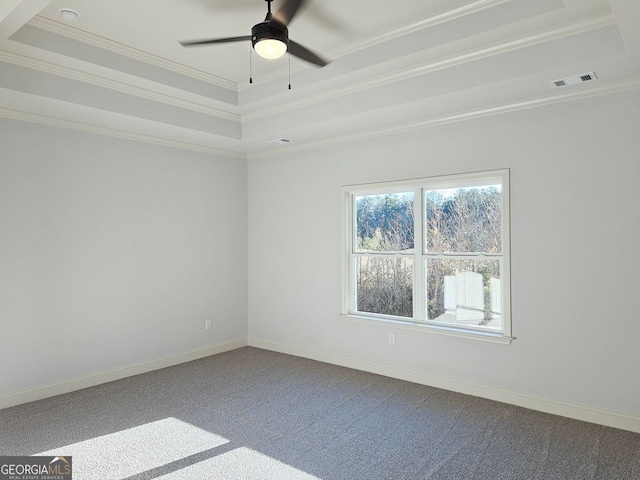 spare room featuring ornamental molding, a tray ceiling, carpet, and visible vents