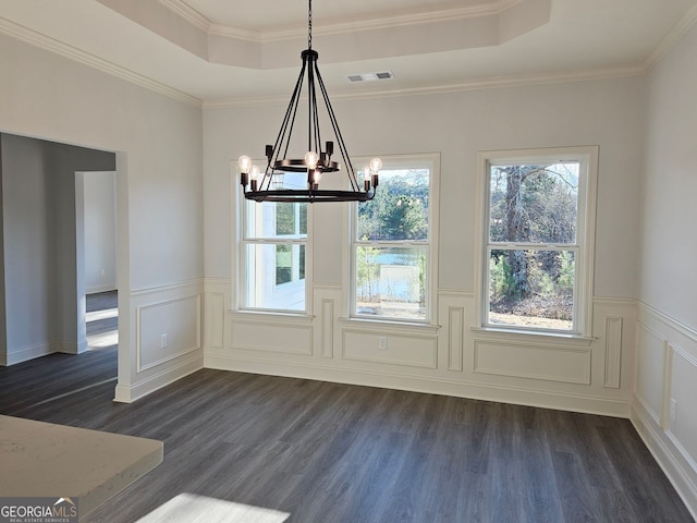 unfurnished dining area featuring dark wood-type flooring, a tray ceiling, and visible vents