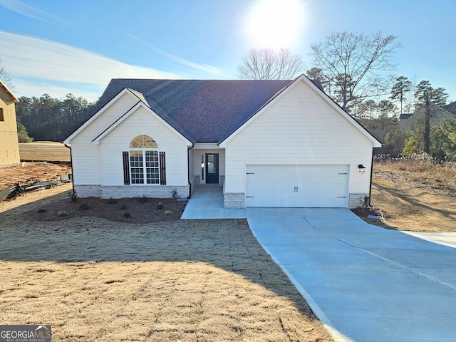 ranch-style home with a garage, driveway, a shingled roof, and brick siding