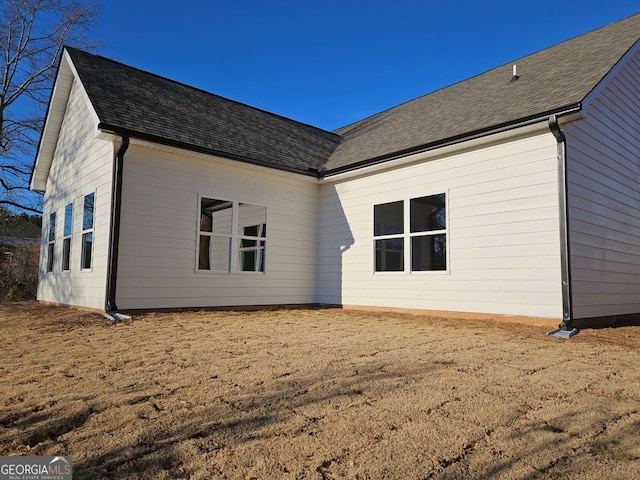 rear view of property featuring roof with shingles