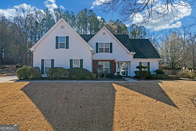 traditional home with a front lawn and brick siding