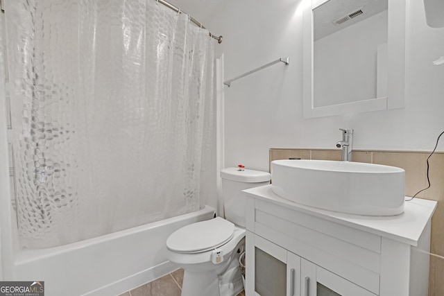 bathroom with visible vents, toilet, shower / bath combo, vanity, and tile patterned floors