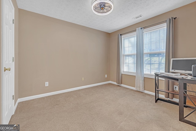 office area with carpet floors, baseboards, visible vents, and a textured ceiling