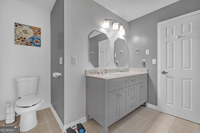 full bathroom featuring double vanity, a sink, toilet, and tile patterned floors