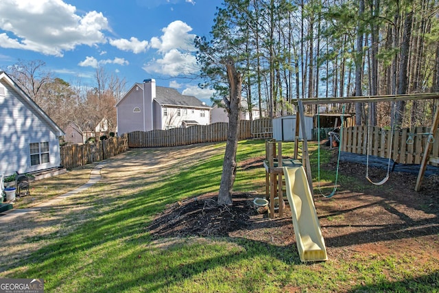 view of jungle gym featuring a storage shed, a fenced backyard, a lawn, and an outdoor structure