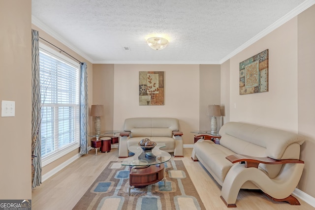 living room with ornamental molding, a textured ceiling, baseboards, and wood finished floors