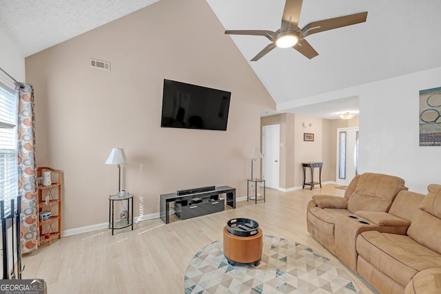 living area featuring high vaulted ceiling, wood finished floors, a ceiling fan, visible vents, and baseboards