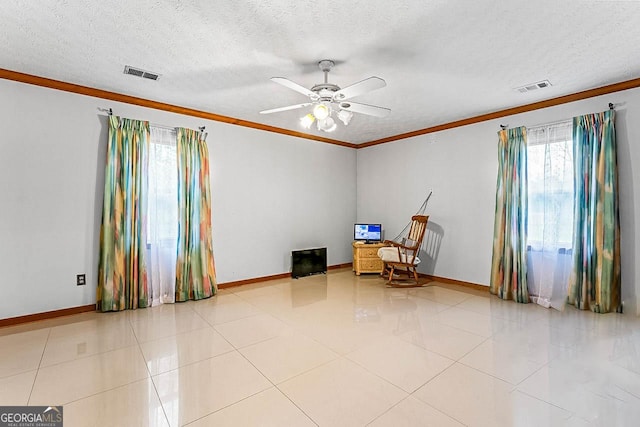 interior space featuring baseboards, visible vents, a textured ceiling, and ornamental molding