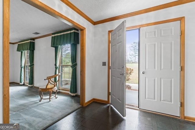 entryway with visible vents, crown molding, a textured ceiling, and baseboards