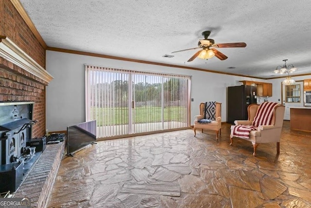 living area featuring a wood stove, visible vents, a textured ceiling, and ornamental molding