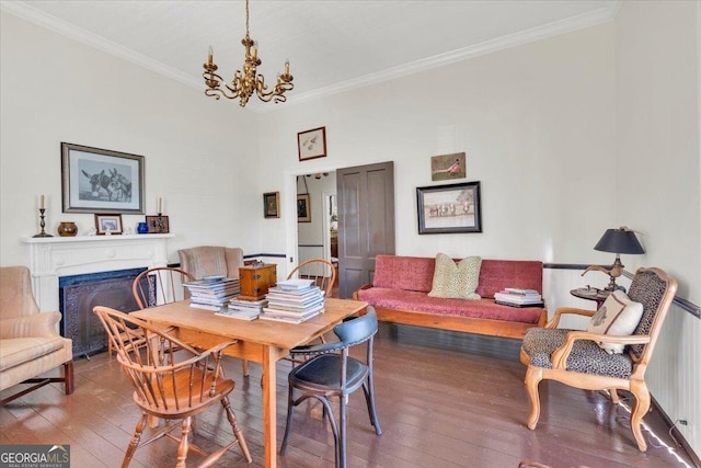 dining area with crown molding, a chandelier, a fireplace, and hardwood / wood-style floors