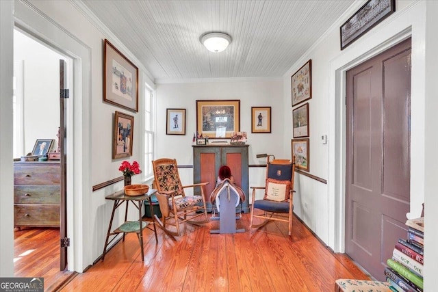 living area featuring light wood finished floors and ornamental molding