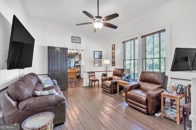 living area with ceiling fan with notable chandelier and hardwood / wood-style floors