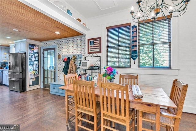 dining space featuring an inviting chandelier, wood ceiling, dark wood finished floors, and crown molding