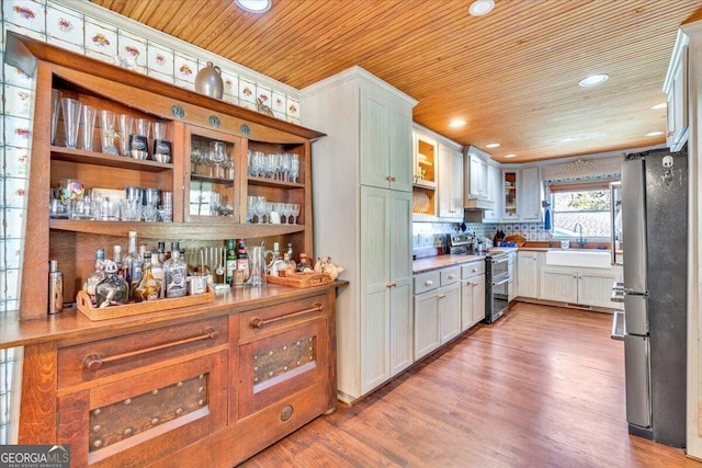 kitchen with wood ceiling, stainless steel appliances, a sink, and light wood-style flooring